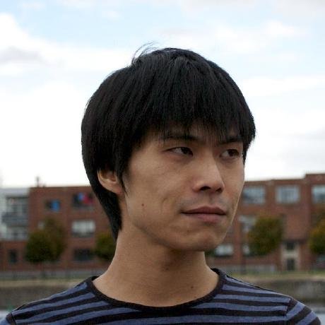 A profile of a person looking to the right. There are buildings behind them in the distance.